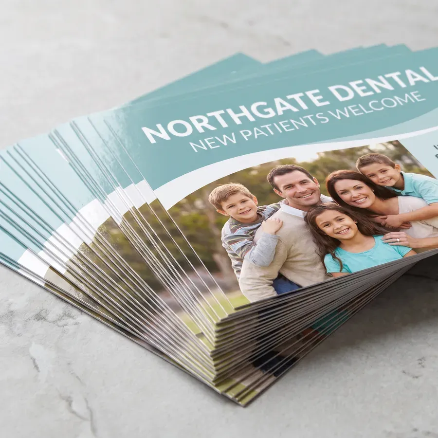 A fanned stack of full color 5 x 7 inch Northgate Dental new patients welcome postcards on thick glossy 16pt cardstock