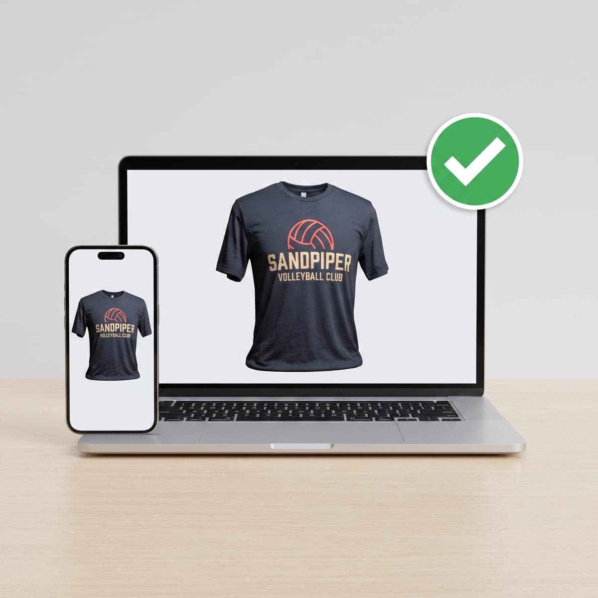 Laptop and phone showing the Sandpiper Volleyball Club shirt mockup with a green approval check