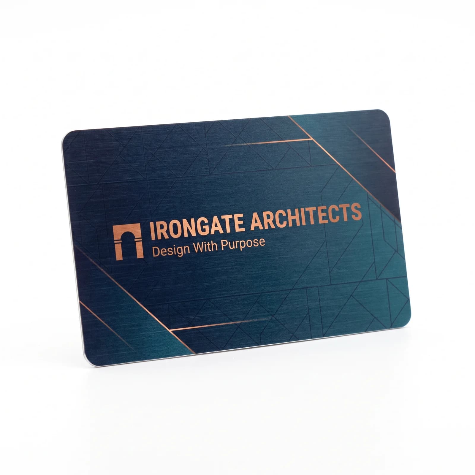 A single Irongate Architects aluminum card standing on a white studio ground, a navy to teal geometric print with copper rule lines, the company name and the line Design With Purpose
