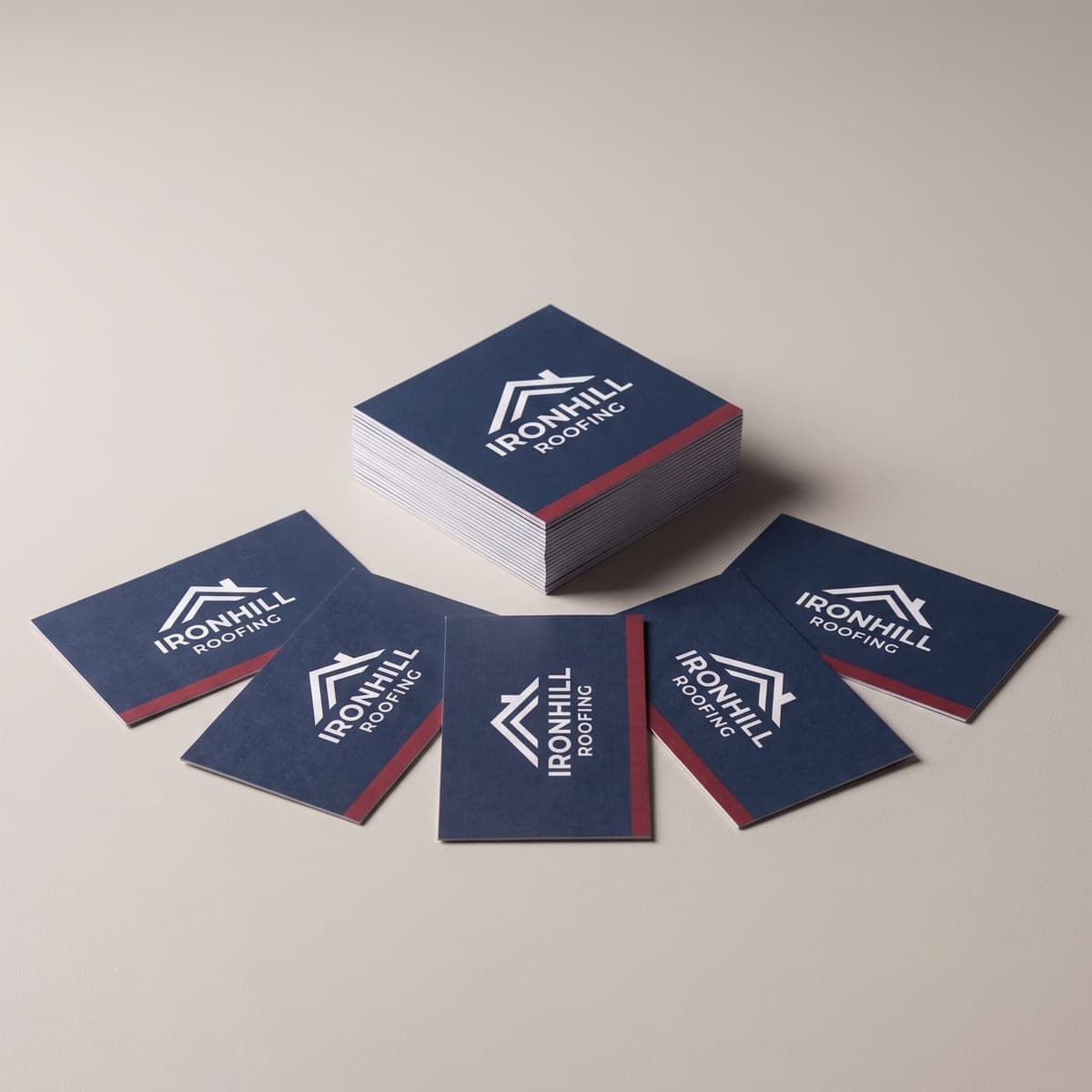 Stack of navy Ironhill Roofing business cards with fanned cards in front in a studio