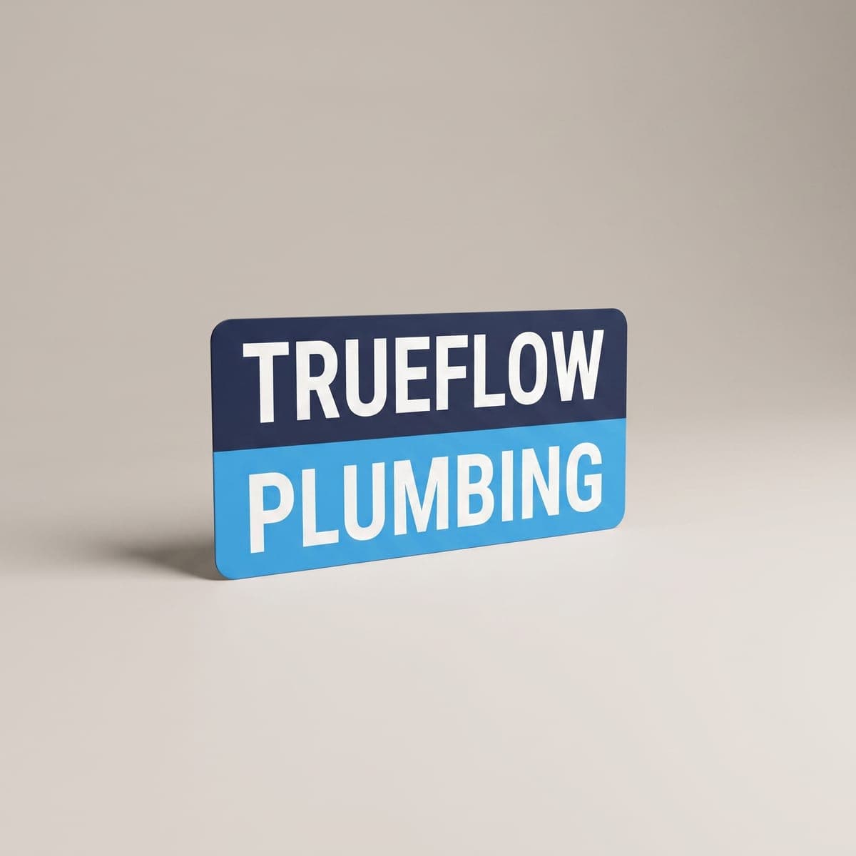 Navy and sky blue Trueflow Plumbing vehicle magnet standing in a studio
