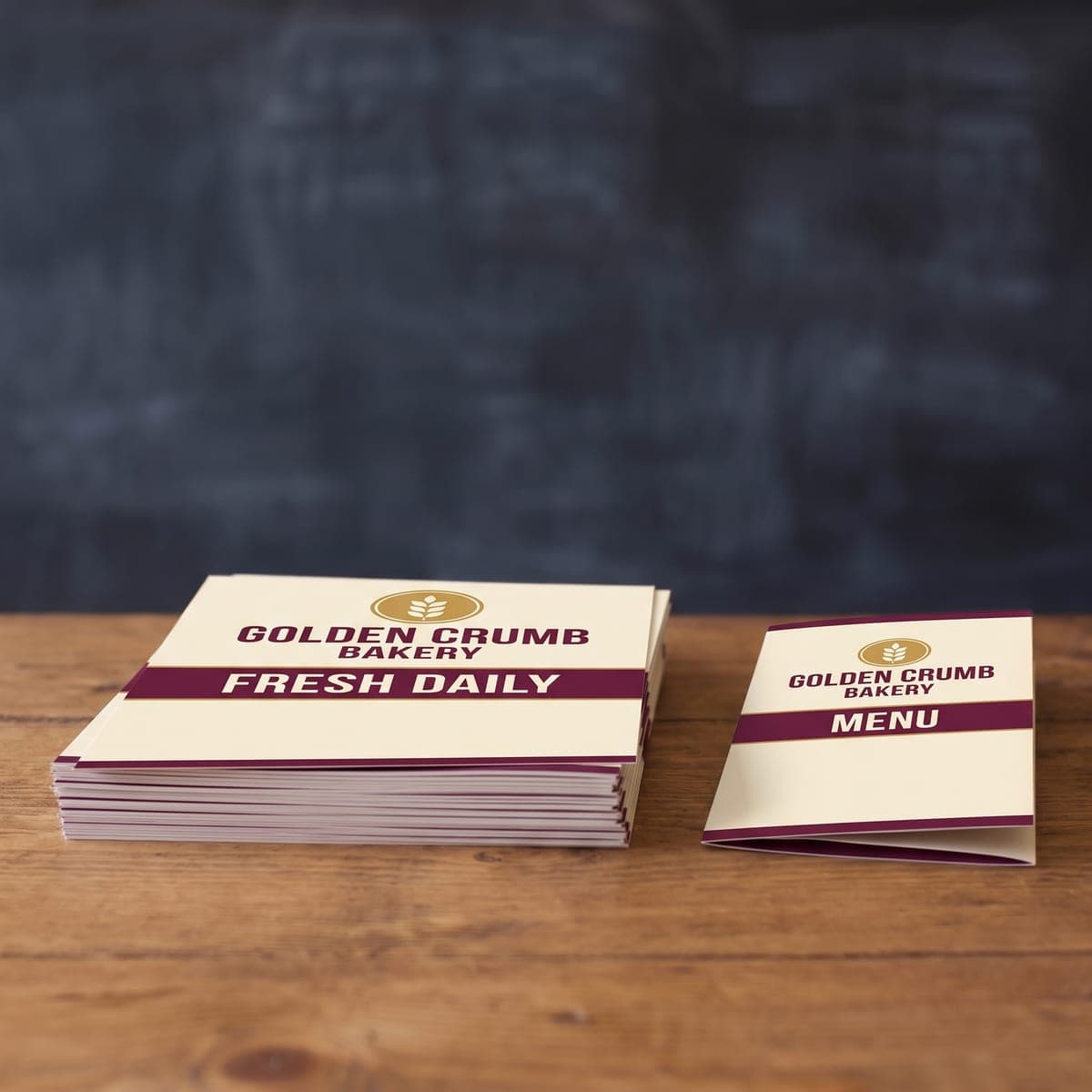 The finished Golden Crumb Bakery flyers and folded menu on a wooden bakery counter
