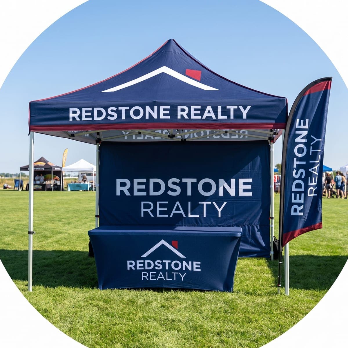 The finished Redstone Realty canopy tent package set up on grass at a real outdoor event