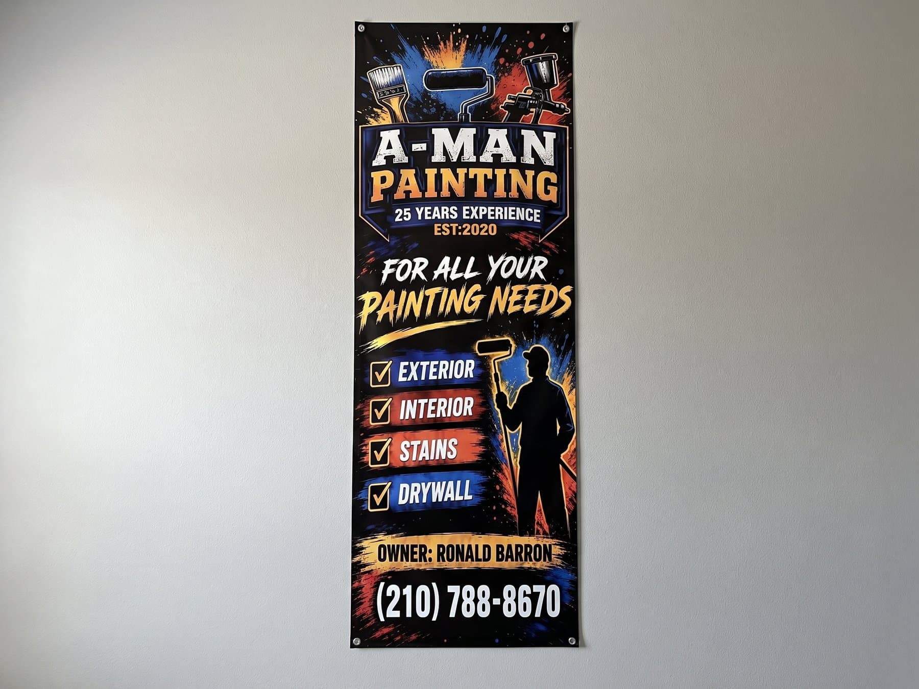 Tall A-Man Painting vinyl banner hung flat against a plain wall, with the logo and years in business at the top, a four line checklist of services through the middle and the owner's phone number in the largest type at the bottom