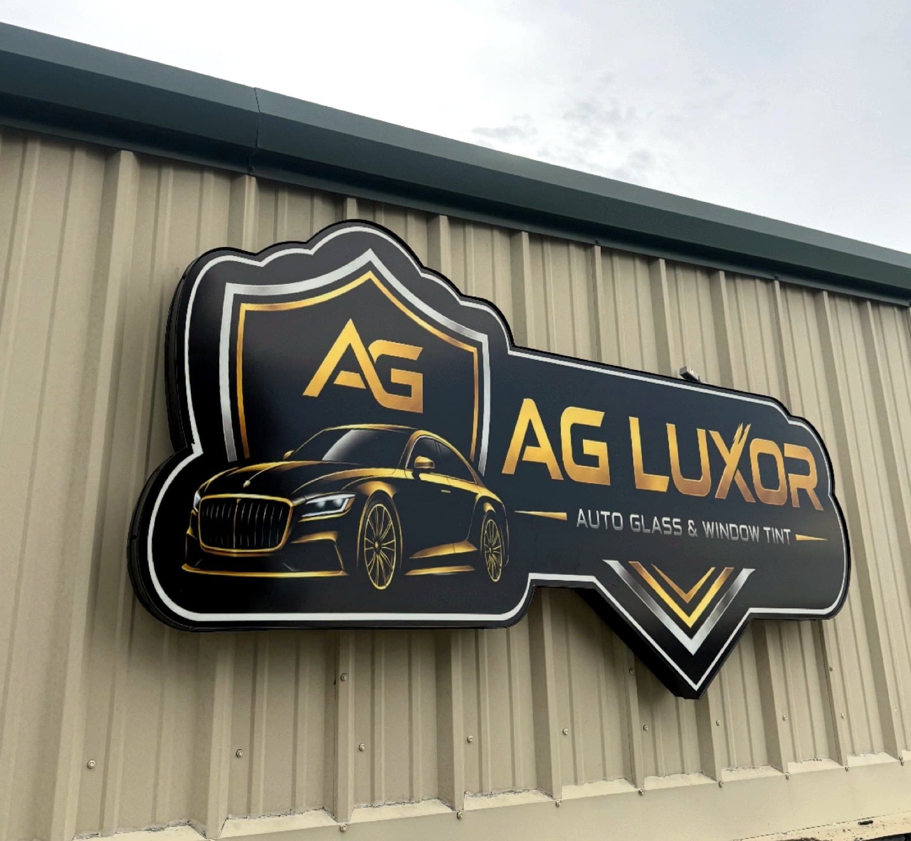 Install-day photo of the AG Luxor sign on the metal building wall, taken on site