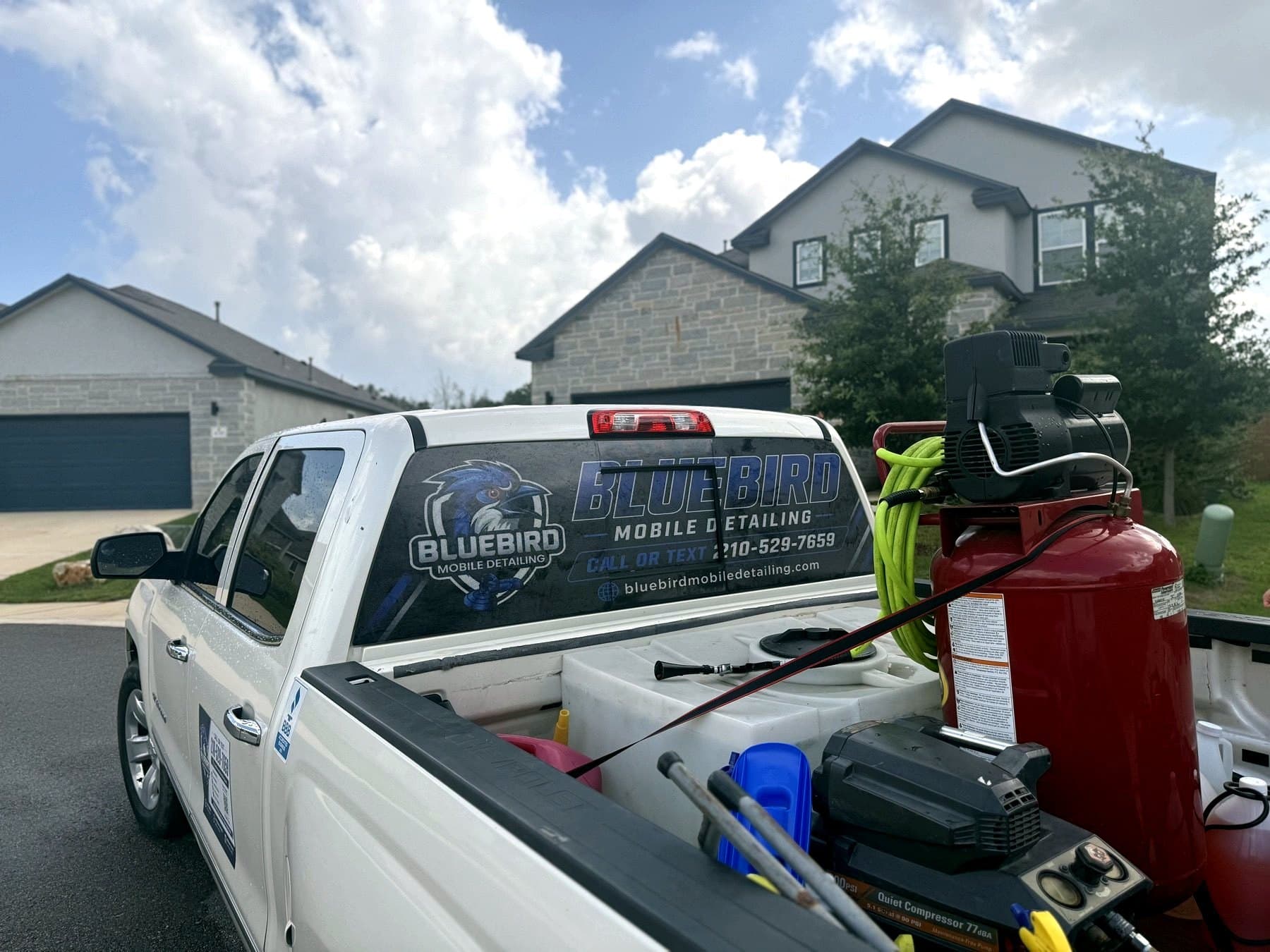 On-site photo of the BlueBird Mobile Detailing truck with the rear window graphic, loaded for the day