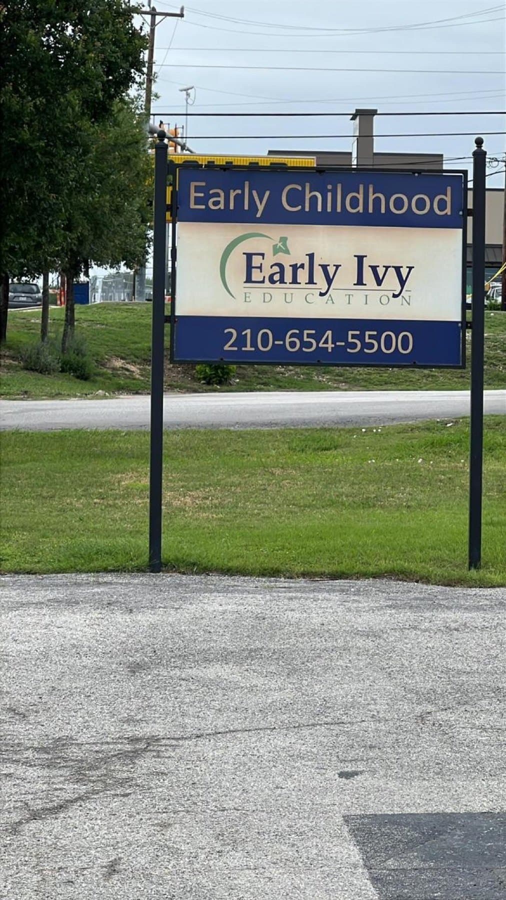 The previous Early Ivy Education sign panel on the same two posts before the rebrand