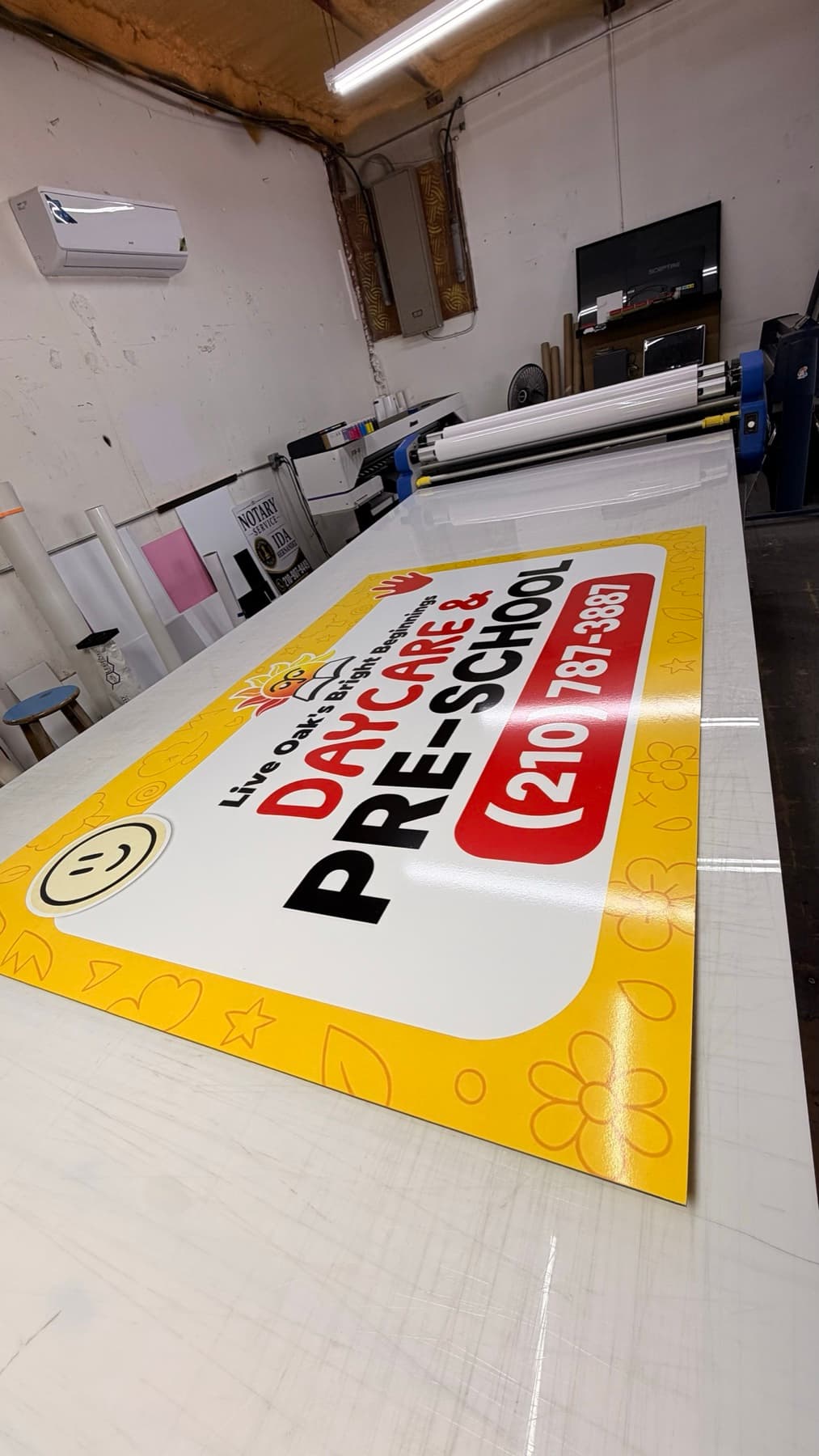 The printed Daycare and Pre-School sign panel on the shop table after lamination, before installation