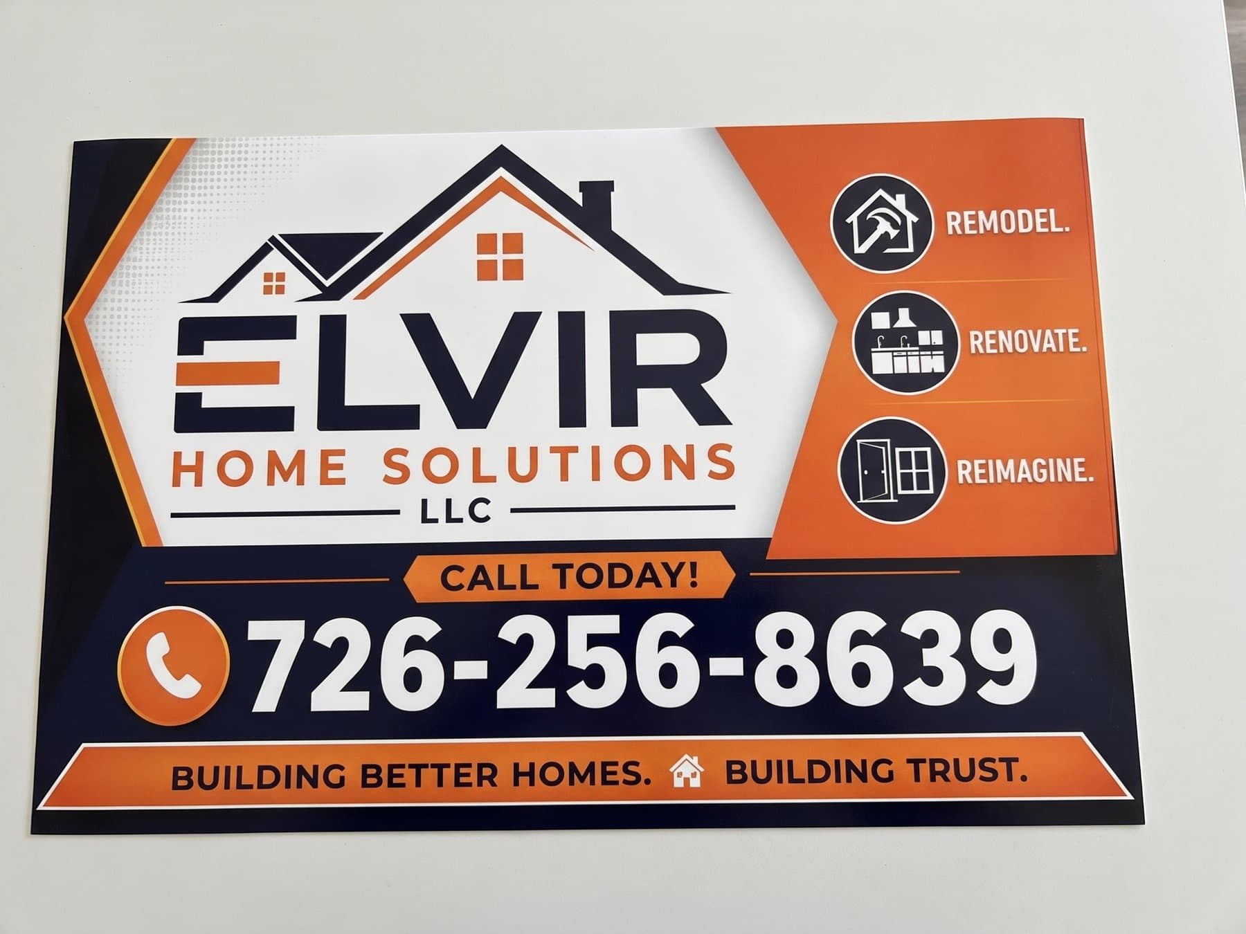 Elvir Home Solutions vehicle magnet photographed flat, with the house mark and name on white, three orange service icons down the right and the phone number across the navy band