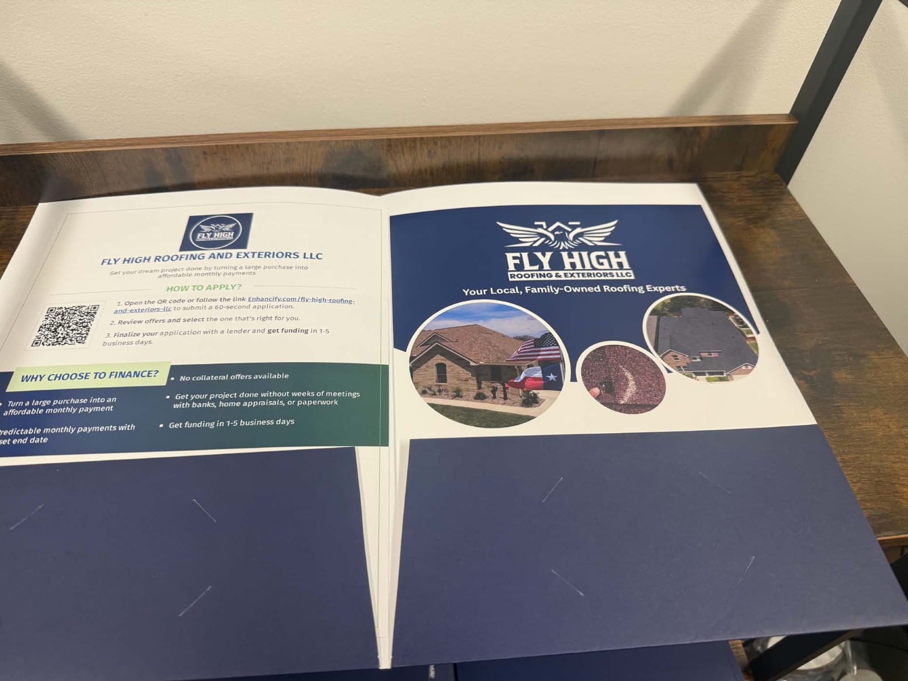 Delivery photo of the Fly High Roofing folder open on the desk with a printed insert in the pocket