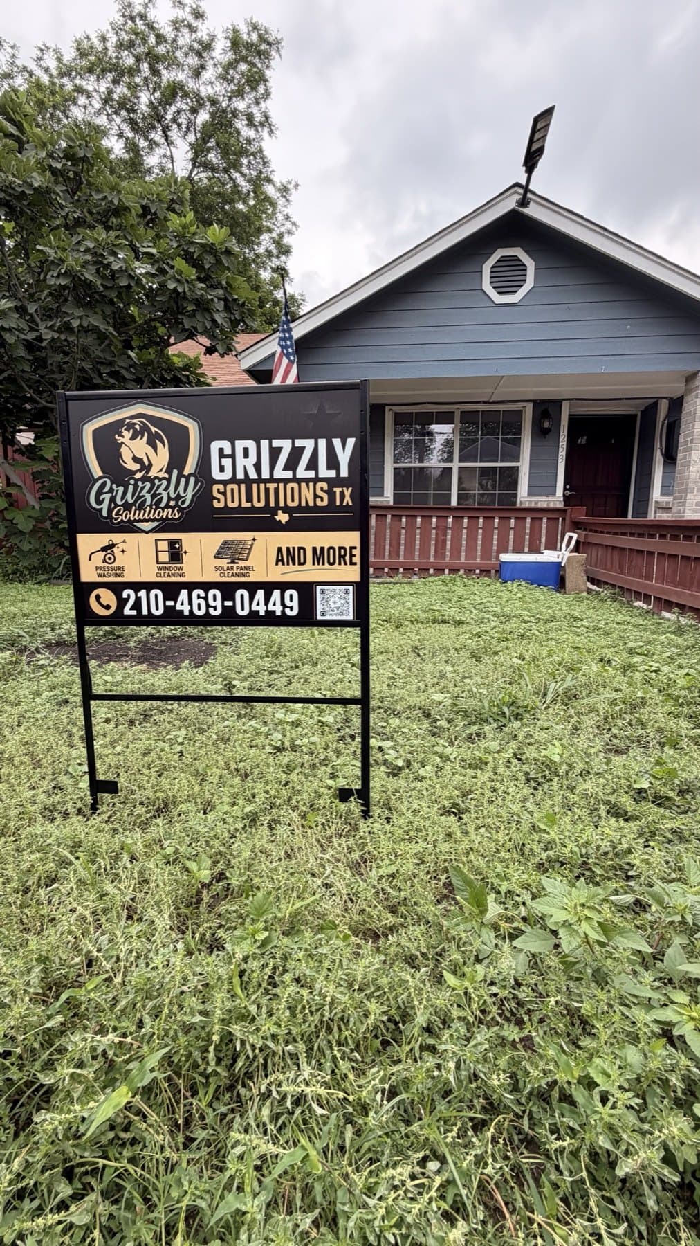 Install-day photo of the Grizzly Solutions yard sign staked in a front yard mid-job, taken on site