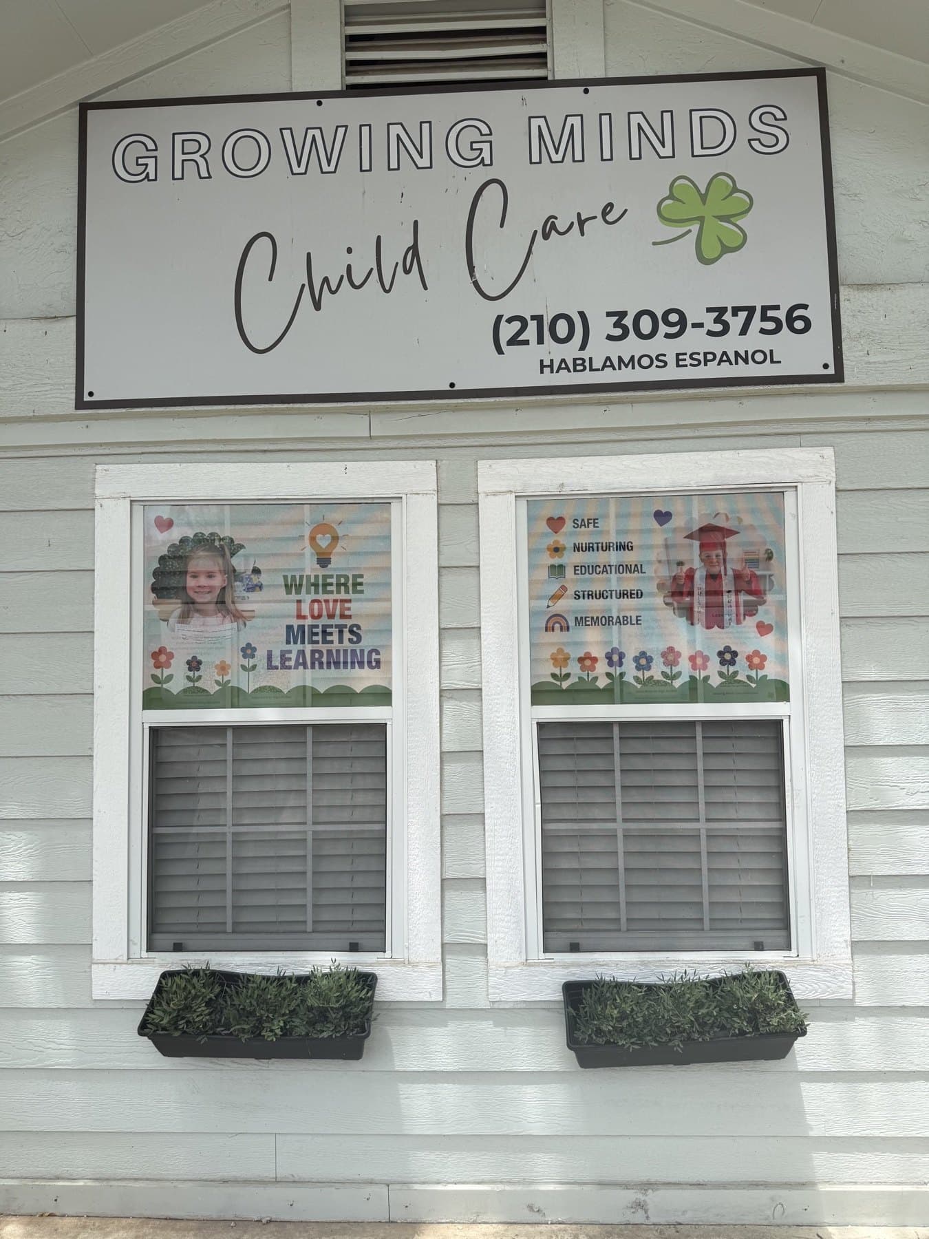 Front of the Growing Minds Child Care building with the name board above two printed windows