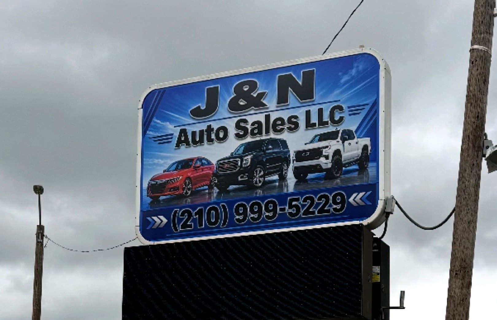 Install-day photo of the J and N Auto Sales pylon face above the message board, taken on site