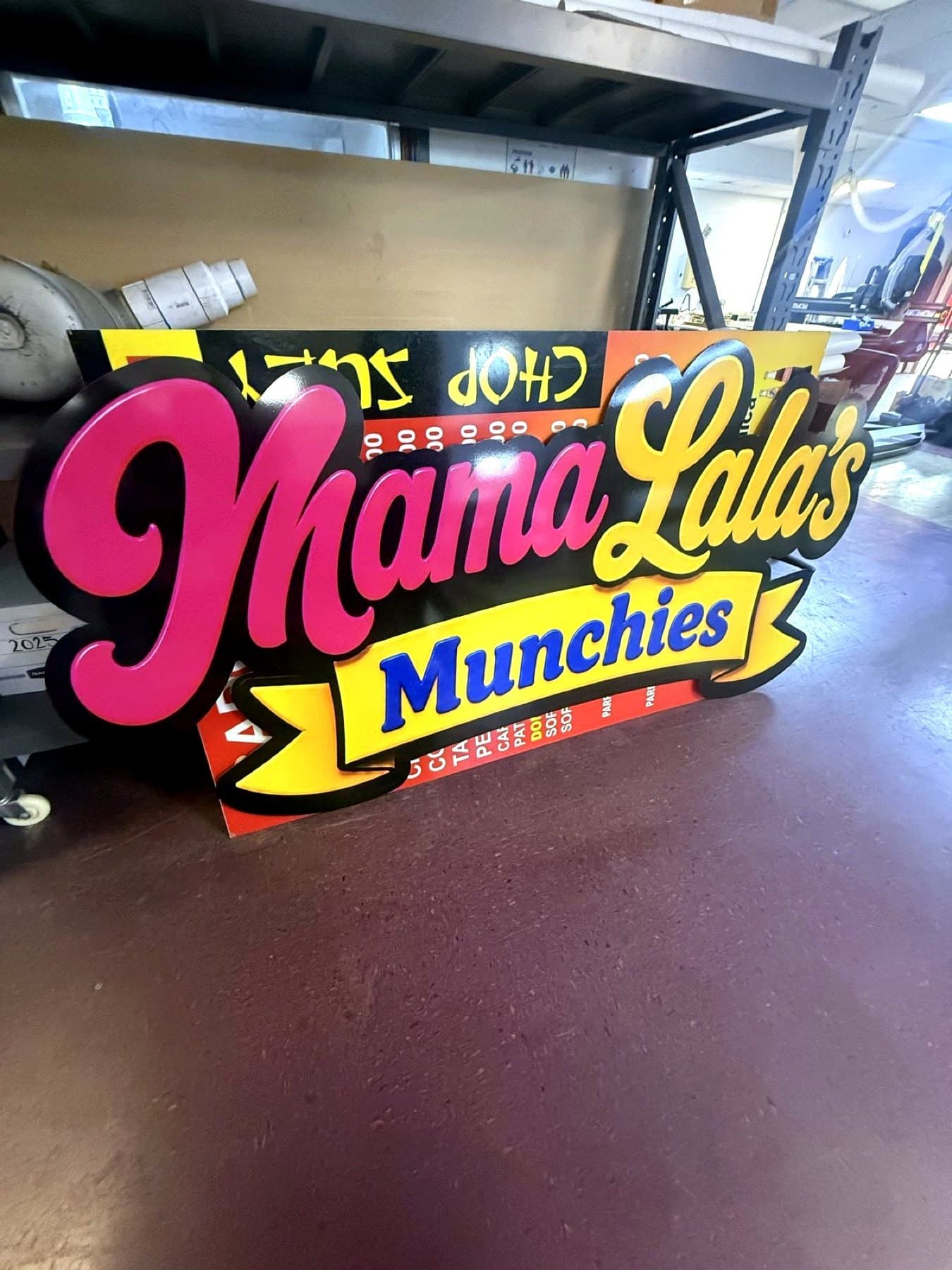 Shop-floor photo of the finished Mama Lala's Munchies sign staged before install