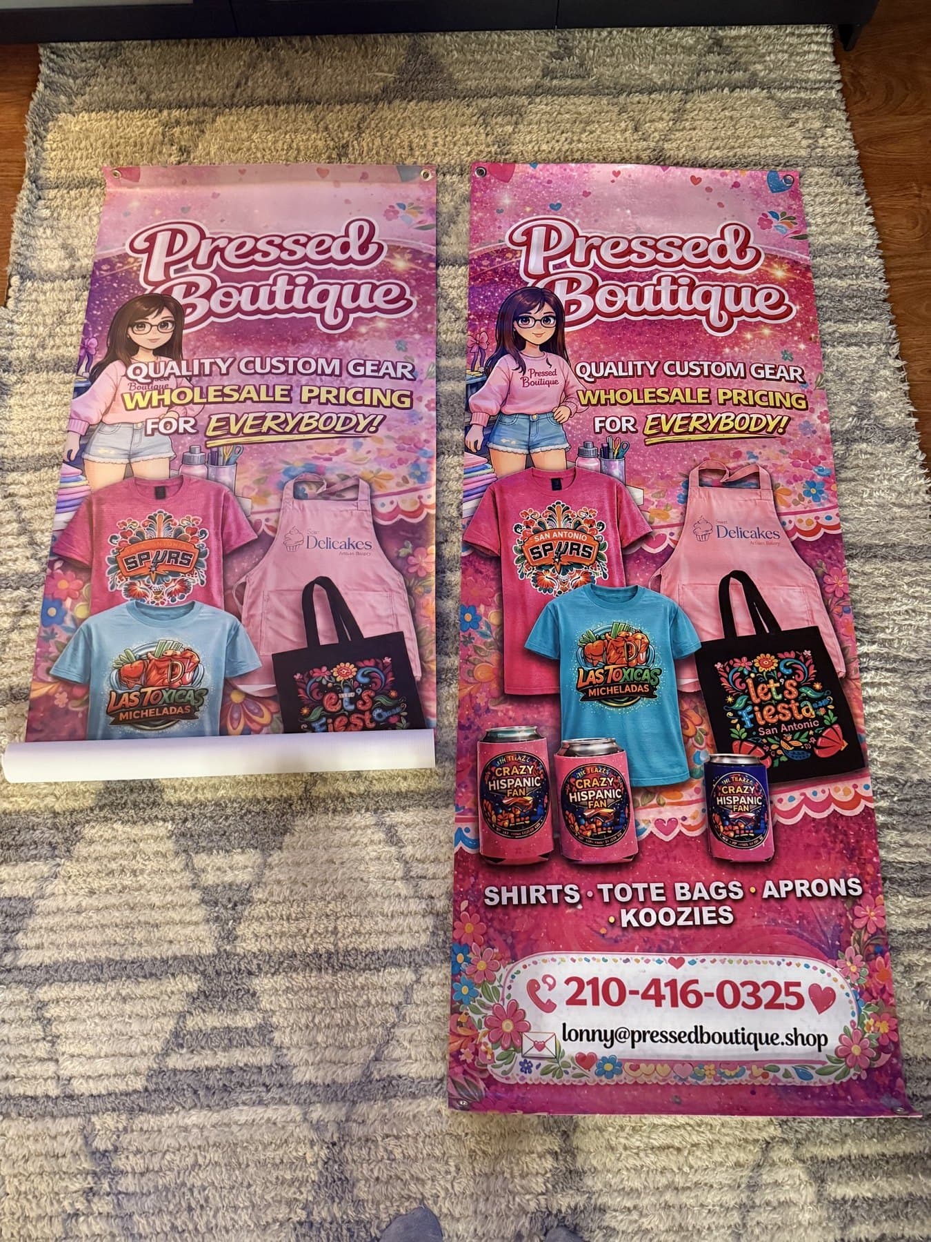 Two Pressed Boutique retractable banner prints laid out on the floor, showing the full artwork