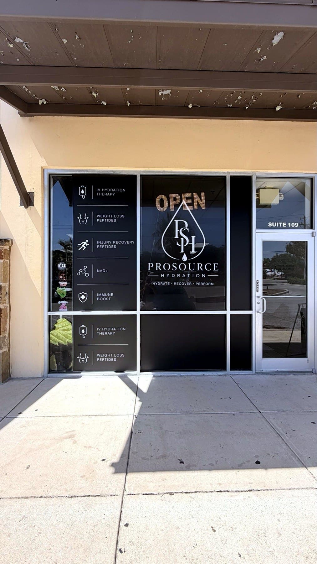 Install-day photo of the ProSource Hydration window graphics on the suite glass, taken on site