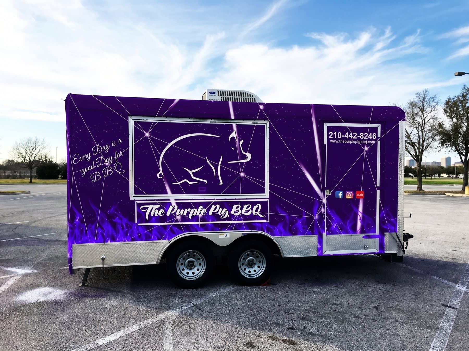 The Purple Pig BBQ concession trailer wrapped corner to corner in deep purple, the line-art pig framed on the long side with purple flame along the bottom and the contact details beside the service door