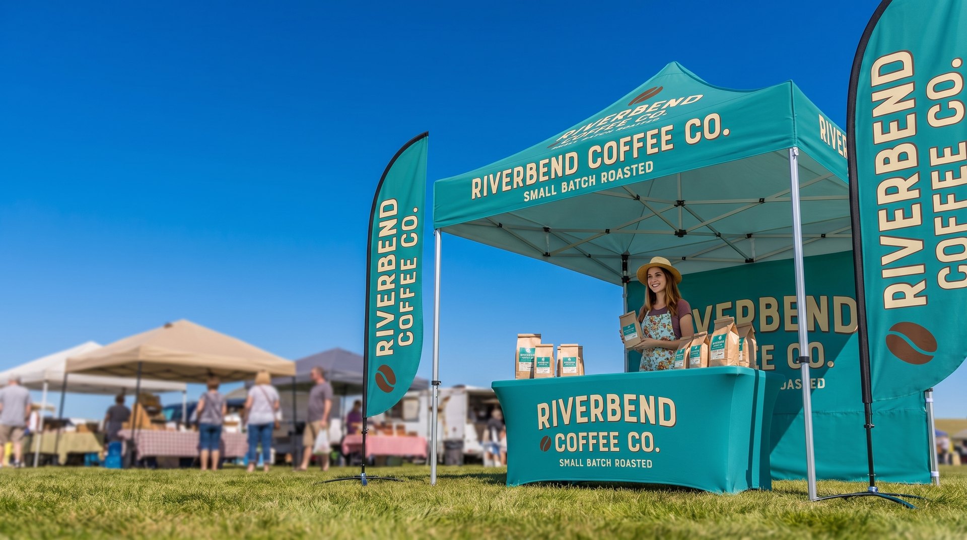 Printed canopy tent, table cover and feather flags for the fictional Riverbend Coffee Co. set up at a sunny farmers market